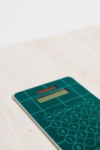 Kaboompics - Teal Calculator Cropped on Beige Stone with Copy Space for Math Lessons and School Graphics