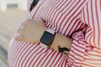 Kaboompics - Maternity Close-Up with Smartwatch over Striped Pregnancy Belly