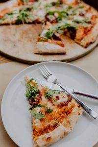 Kaboompics - Close-Up of Pizza Slice Served with a Fork on a White Plate