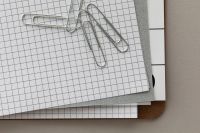 Kaboompics - Layered Grid Paper and Paper Clips Editorial Background with Copy Space