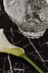 Kaboompics - Calla Lily and Glass Vase Still Life on Black Marble with Neutral Backdrop