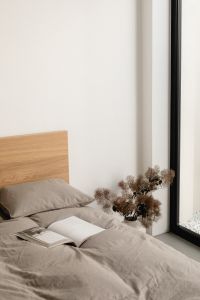 Kaboompics - Open Book and Dried Flowers on a Bed by a Window