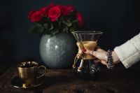 Kaboompics - Glass Chemex Brewer and Gold Coffee Cup with Red Roses, Wide Rustic Coffee Still Life