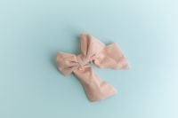 Kaboompics - Small pastel fabric bow on blue background minimal composition