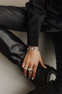 Kaboompics - Ringed Hand and Black Leather Boot in Dark Fashion Detail