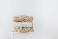 Kaboompics - Neutral Knitwear Stack on White Stool