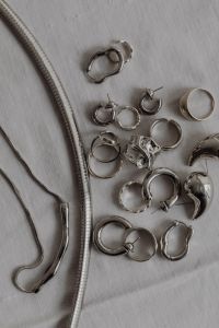Kaboompics - Silver Chain and Rings on White Tablecloth