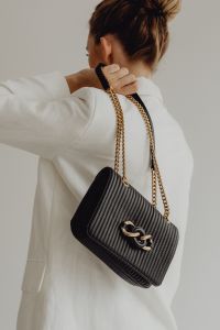 Kaboompics - Woman Carrying Black Ribbed Chain Strap Shoulder Bag over White Blazer