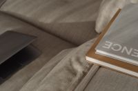 Kaboompics - Wide Close-Up of Laptop and Books on a Textured Sofa, Minimal Home Office
