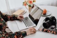 Kaboompics - Woman Working at a Laptop Beside a DSLR Camera