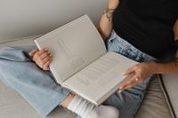 Kaboompics - Woman Reading on a Sofa in Light Jeans and Cozy Socks