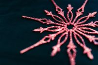 Kaboompics - Pink Glitter Snowflake Ornament on Dark Blue Background
