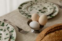 Kaboompics - Easter Eggs in Egg Cup with Bread and Plates