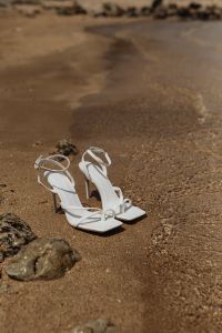 Kaboompics - White Strap Sandals on Wet Sand with Open Background