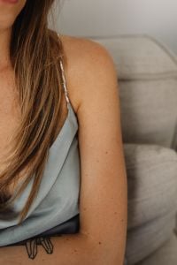 Kaboompics - Close-Up of Woman in a Gray Satin Top Relaxing on a Sofa