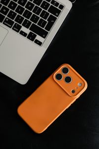 Kaboompics - Top View of Orange Smartphone and Laptop on Black Sofa