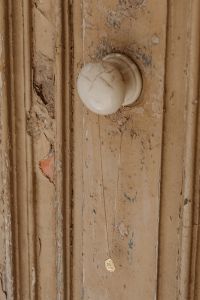 Kaboompics - Minimalist Gold Pendant Necklace on a Distressed Wooden Door, Neutral Jewelry Styling