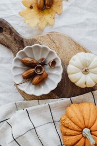 Kaboompics - Flat Lay of Pumpkin Acorns and Autumn Leaves on White Linen