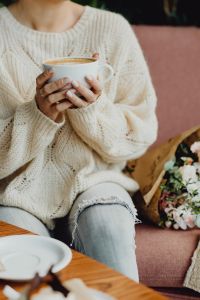 Kaboompics - Hands Holding a Cup of Coffee beside a Pink Sofa and Bouquet