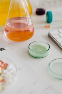 Kaboompics - Chemistry Flask and Green Petri Dish Beside Keyboard