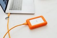 Kaboompics - Man works on a computer at his desk, mobile phone, portable hard drive