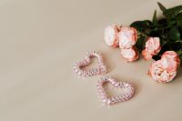 Kaboompics - Pink Roses and Two Beaded Heart Decorations on a Beige Background