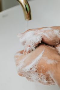 Kaboompics - Rubbing Soap between Hands at a Bathroom Sink, Vertical Public Health Campaign Image