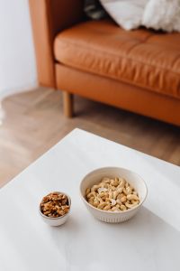 Kaboompics - Cashew Nuts and Walnuts in Ceramic Bowls on a White Coffee Table for Snack Content
