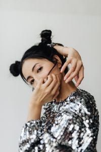 Kaboompics - Asian Woman in Silver Sequin Top Posing with Hands on Her Face