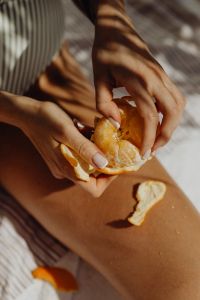 Kaboompics - Vertical Close-Up of Peeling an Orange in the Sun