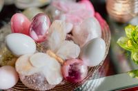 Kaboompics - Close-Up Pastel Easter Eggs and White Feathers beside a Green Glass Candle Holder