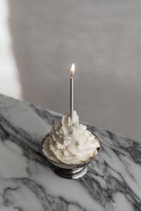 Kaboompics - Whipped Cream Dessert with Candle Close-Up on Arabescato Marble