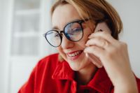 Kaboompics - Smiling Woman on Phone Wearing Glasses at Home Office
