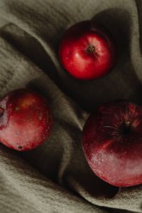 Kaboompics - Single Red Apple on Draped Olive Fabric, Moody Minimal Autumn Still Life