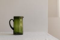 Kaboompics - Green Glass Pitcher on Linen with Spacious Neutral Background