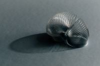 Kaboompics - Silver Spiral Spring Sculpture with Curved Shadow