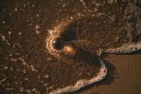 Kaboompics - Black Glass Sphere in Sea Foam from Above