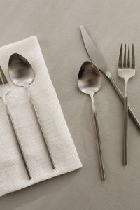 Kaboompics - Close-Up Matte Steel Fork, Knife and Spoons on Textured Neutral Surface