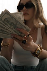 Kaboompics - Woman in Sunglasses Looking at a Fan of Dollar Bills