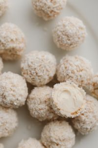 Kaboompics - Close-Up of Coconut-Covered Truffles with a Cut Center, Soft White Dessert Texture