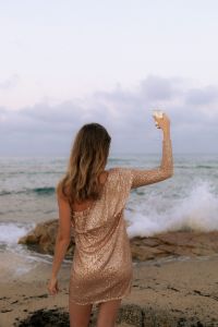 Kaboompics - Woman Holding Champagne by the Sea