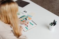 Kaboompics - Blonde Graphic Designer Sketching Lettering beside Color Cards, Markers and Tablet