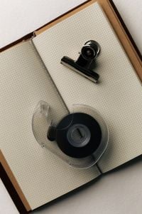Kaboompics - Open Grid Notebook with Black Binder Clip and Clear Tape