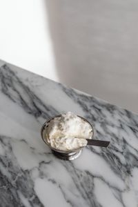 Kaboompics - Whipped Cream Dessert in Silver Bowl with Spoon on Arabescato Marble