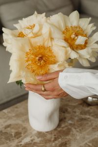 Kaboompics - White Peony Bouquet Held by Hands in a Neutral Interior