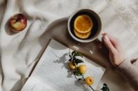 Kaboompics - Open Book and Orange Tea on a Beige Blanket