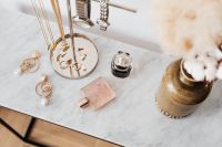 Kaboompics - Marble Vanity with Gold Jewelry, Perfume Bottles and Dried Flowers in a Vase