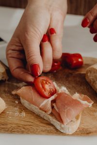 Kaboompics - Adding a Cherry Tomato Slice to Prosciutto Bruschetta