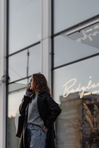 Kaboompics - Woman in Black Leather Coat Outside a Modern Glass Building