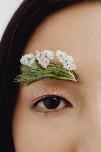 Kaboompics - Vertical Macro of a Single Eye Framed by Floral Eyebrow Art